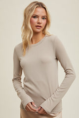 woman wearing a beige long sleeve ribbed top, styled with a round neckline and fitted silhouette