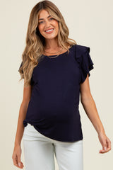 woman wearing a navy blue maternity top with ruffled sleeves and a visible baby bump