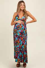 woman wearing a colorful floral maternity maxi dress and holding her baby bump