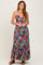 woman wearing a vibrant floral print maxi dress with a halter neckline and tiered hem