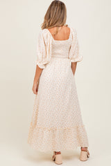 woman wearing a floral maternity maxi dress with puff sleeves and a smocked back, showing her baby bump