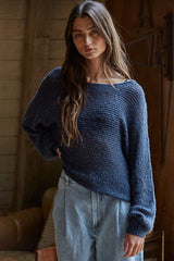 woman wearing a dark blue oversized knitted sweater and light blue high-waisted jeans