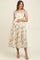 woman wearing a floral print sleeveless maternity dress with tie straps and a visible baby bump