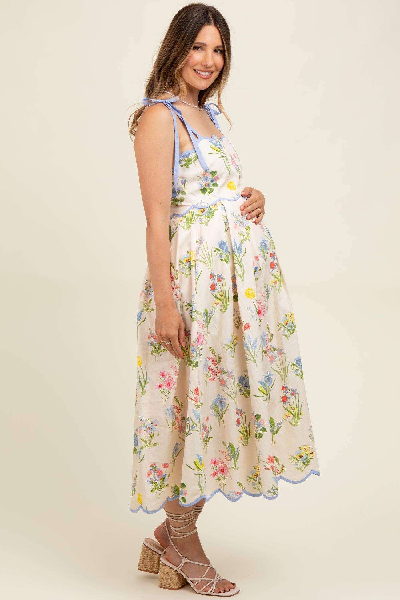 woman wearing a floral print maternity dress with blue accents and a visible baby bump