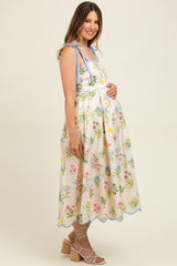 woman wearing a floral print maternity dress with blue accents and a visible baby bump