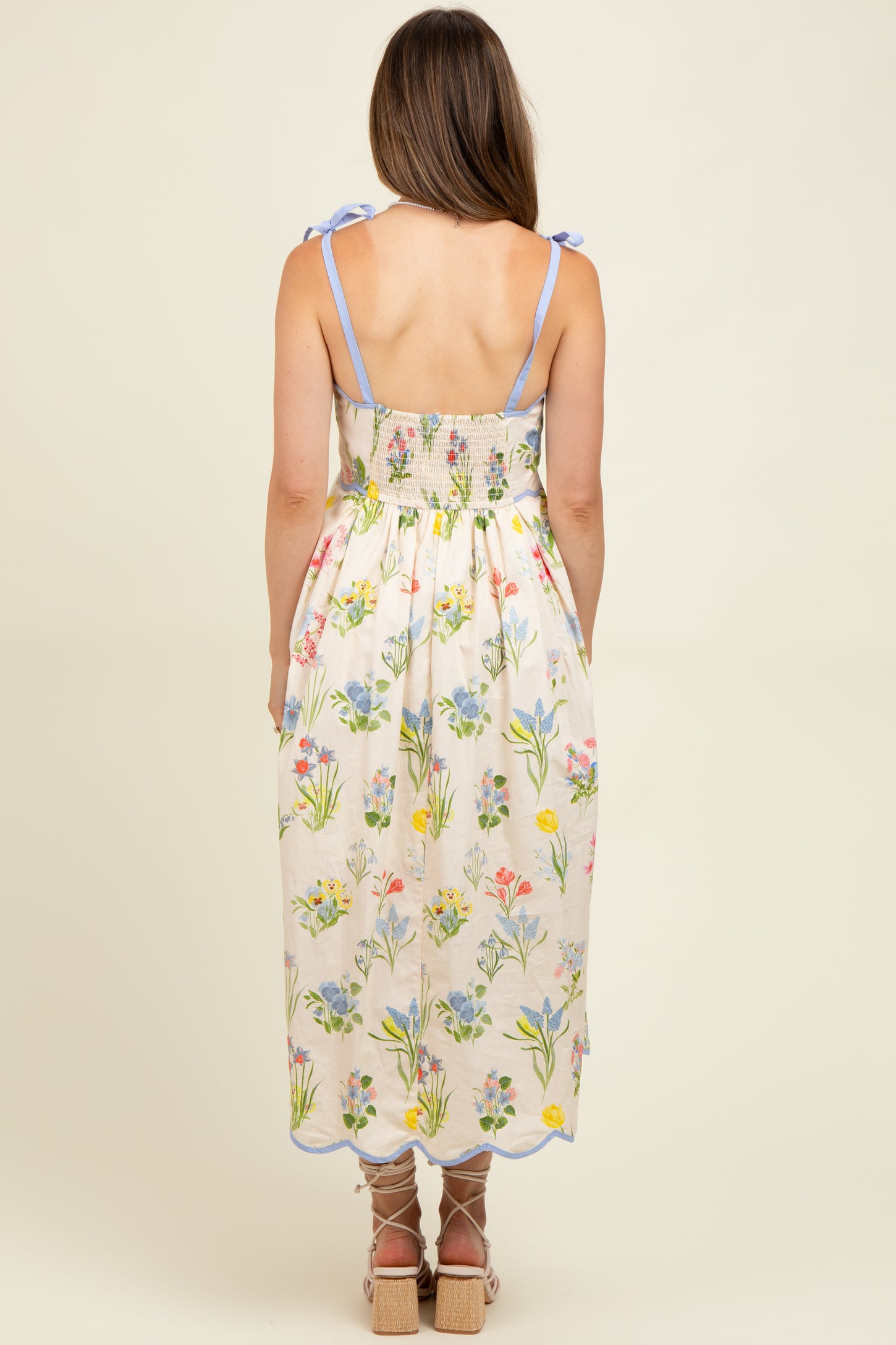 woman wearing a floral maternity maxi dress with back smocking and tie shoulder straps
