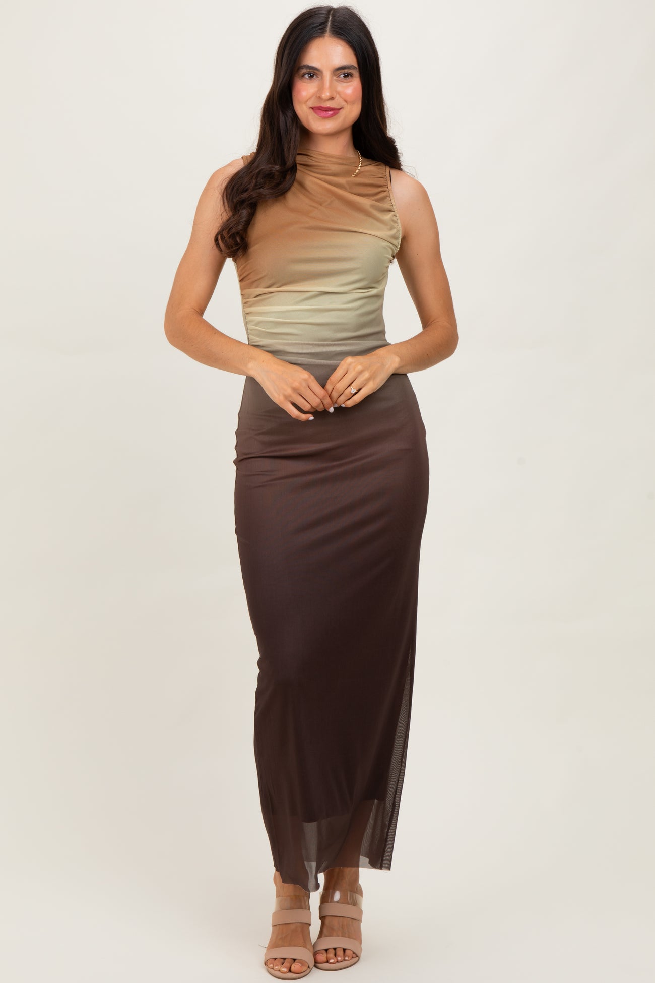woman wearing a color-blocked sleeveless top transitioning from light beige to brown with a matching brown maxi skirt