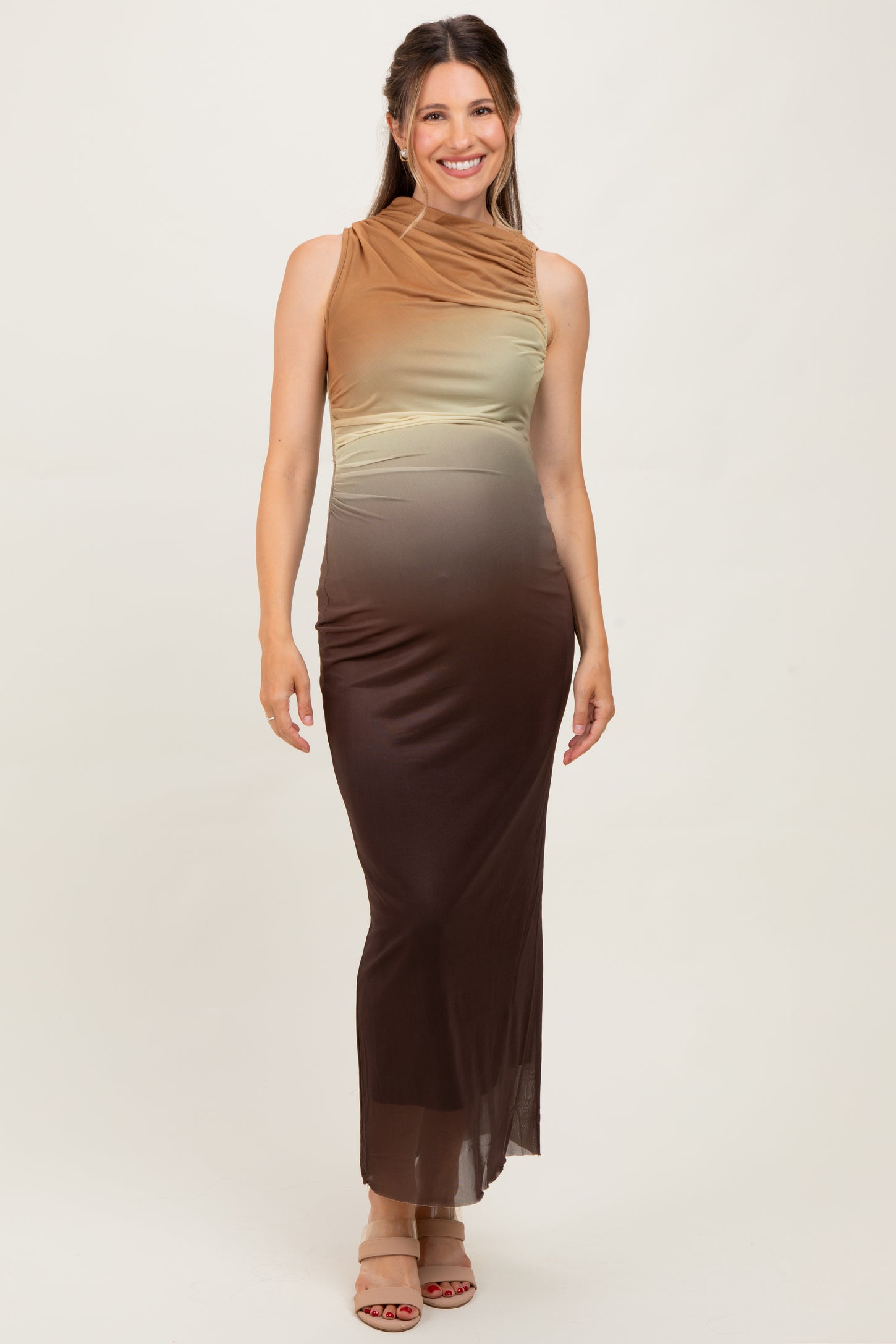 woman wearing a sleeveless ombre maternity maxi dress in shades of brown and green, highlighting her baby bump