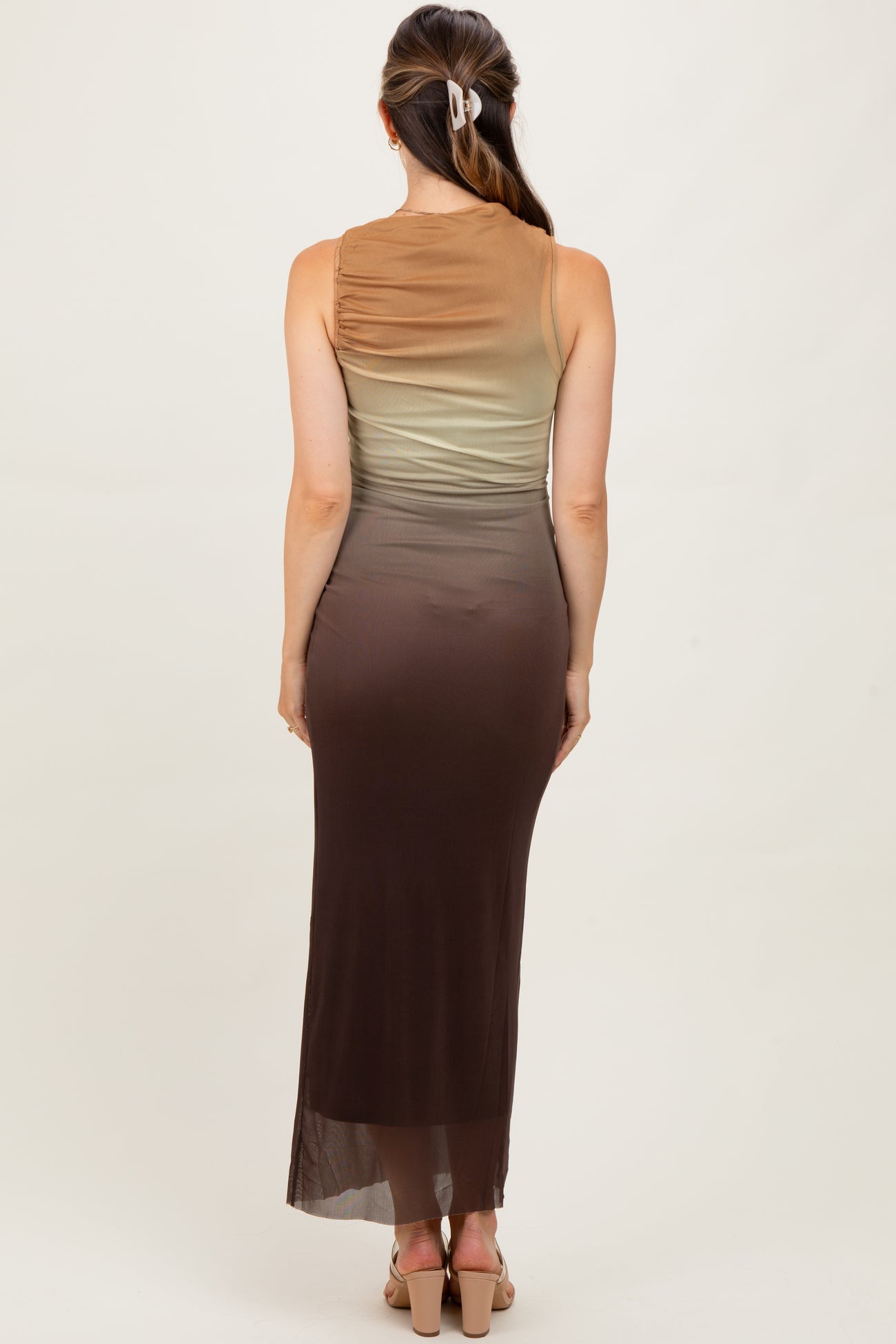 woman wearing a sleeveless ombre maternity dress with a fitted silhouette in shades of green to brown