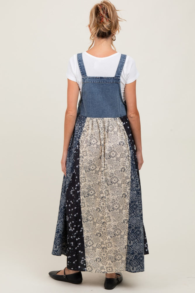 woman wearing a maternity denim overall dress with a patterned skirt, showing the back view and a relaxed fit