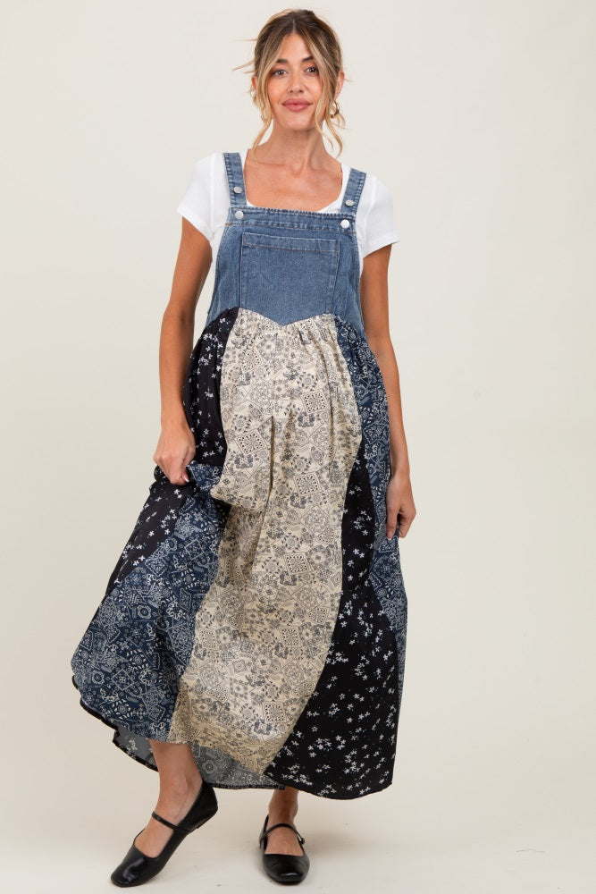 woman wearing a denim maternity overall dress with a patchwork skirt in floral and bohemian patterns