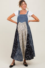 woman wearing a denim patchwork maternity dress with floral prints and a fitted bodice, showing her baby bump