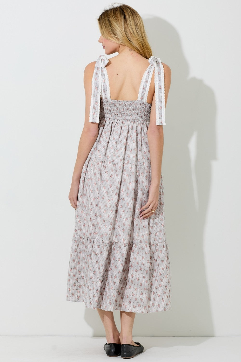 woman wearing a backless floral maxi dress with smocked bodice and tie straps