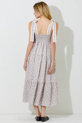woman wearing a backless floral maxi dress with smocked bodice and tie straps
