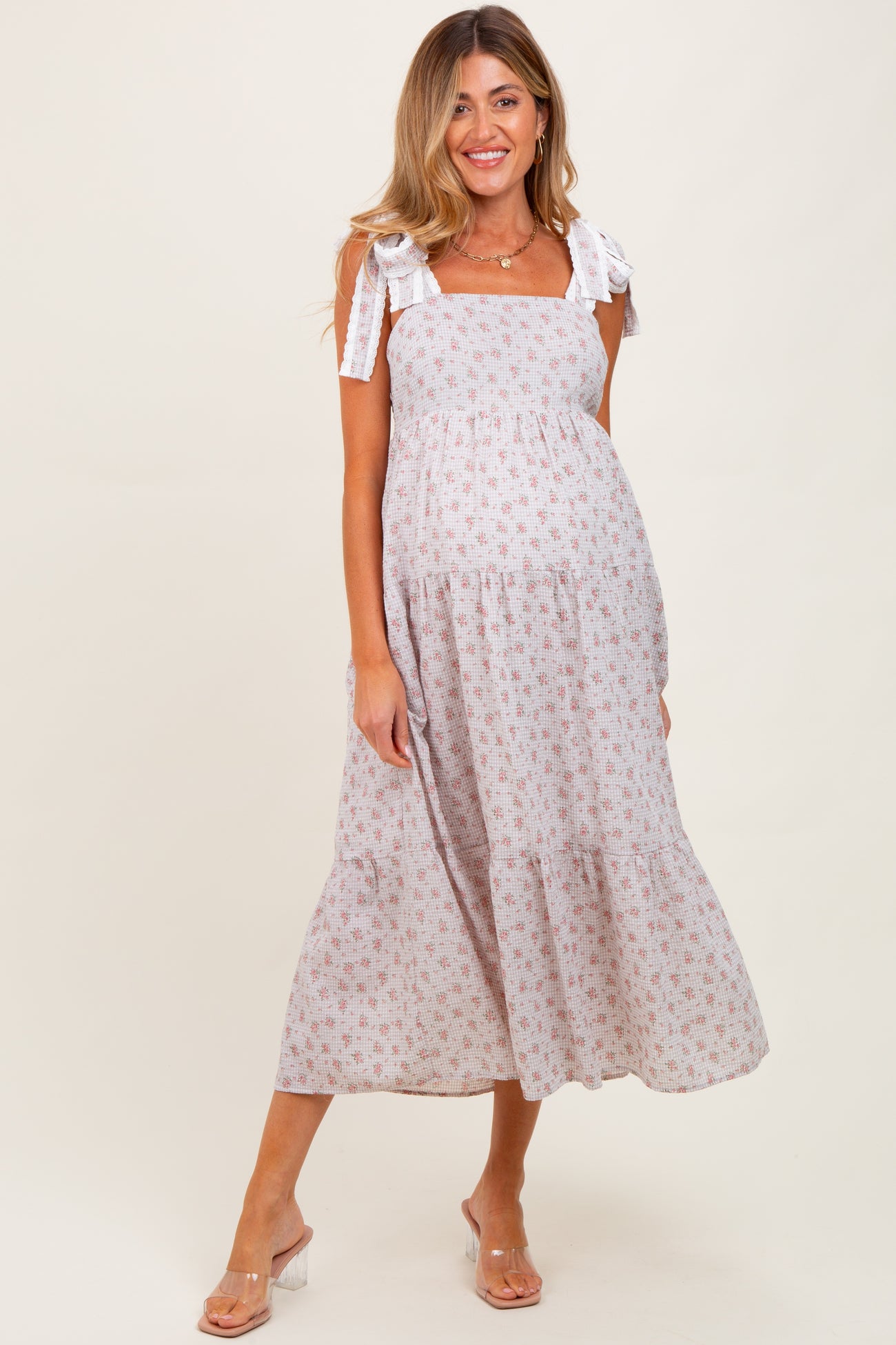 woman wearing a floral print maternity maxi dress with tie straps and a baby bump visible