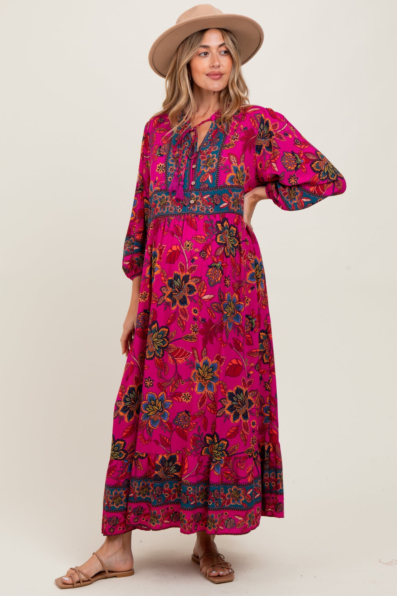 woman wearing a pink floral maternity maxi dress with bell sleeves and a keyhole neckline