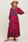 woman wearing a pink floral maternity maxi dress with bell sleeves and a keyhole neckline