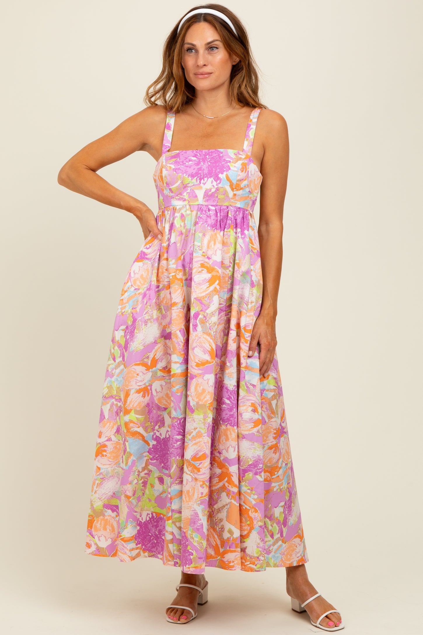 woman wearing a colorful floral maxi dress with square neckline and adjustable straps