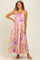 woman wearing a colorful floral maxi dress with square neckline and adjustable straps