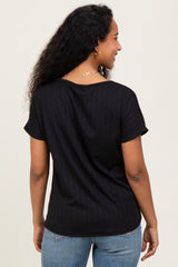 woman wearing a black short sleeve maternity top, viewed from the back, showing a relaxed fit and subtle ribbed texture