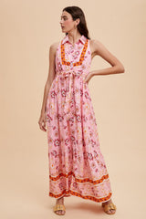 woman wearing a pink floral maxi dress with a tied waist and a collar, styled for a summer look