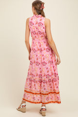woman wearing a pink floral maxi maternity dress with a cinched waist and back detail
