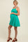 woman wearing a teal maternity dress with a tiered skirt and holding her baby bump