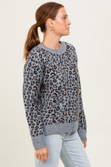 woman wearing a gray leopard print sweater with a relaxed fit and ribbed hem, styled with light blue jeans
