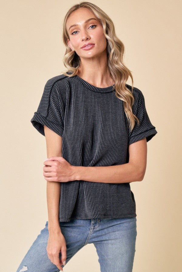 woman wearing a black and white striped short sleeve top with rolled sleeves and a relaxed fit, paired with blue jeans