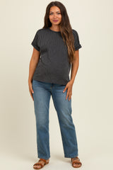 woman wearing a black and white striped maternity top with short sleeves and blue jeans, standing casually