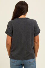 woman wearing a dark gray ribbed maternity top with rolled sleeves, showing the back view and paired with blue jeans