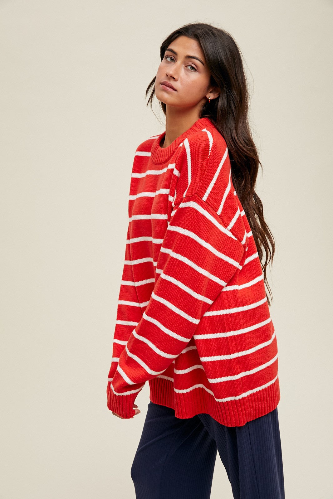 woman wearing a red and white striped oversized sweater with long sleeves and relaxed fit