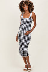 woman wearing a black and white gingham maternity dress, showing her baby bump, standing in a relaxed pose