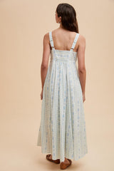 woman wearing a back-view light blue floral maxi dress with adjustable straps and a smocked bodice