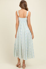 woman wearing a light blue floral print maternity maxi dress with adjustable straps and smocked back detail