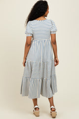 woman wearing a striped midi dress with puff sleeves and a tiered skirt, viewed from the back