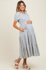 woman wearing a striped maternity dress with short sleeves and pockets, highlighting her baby bump