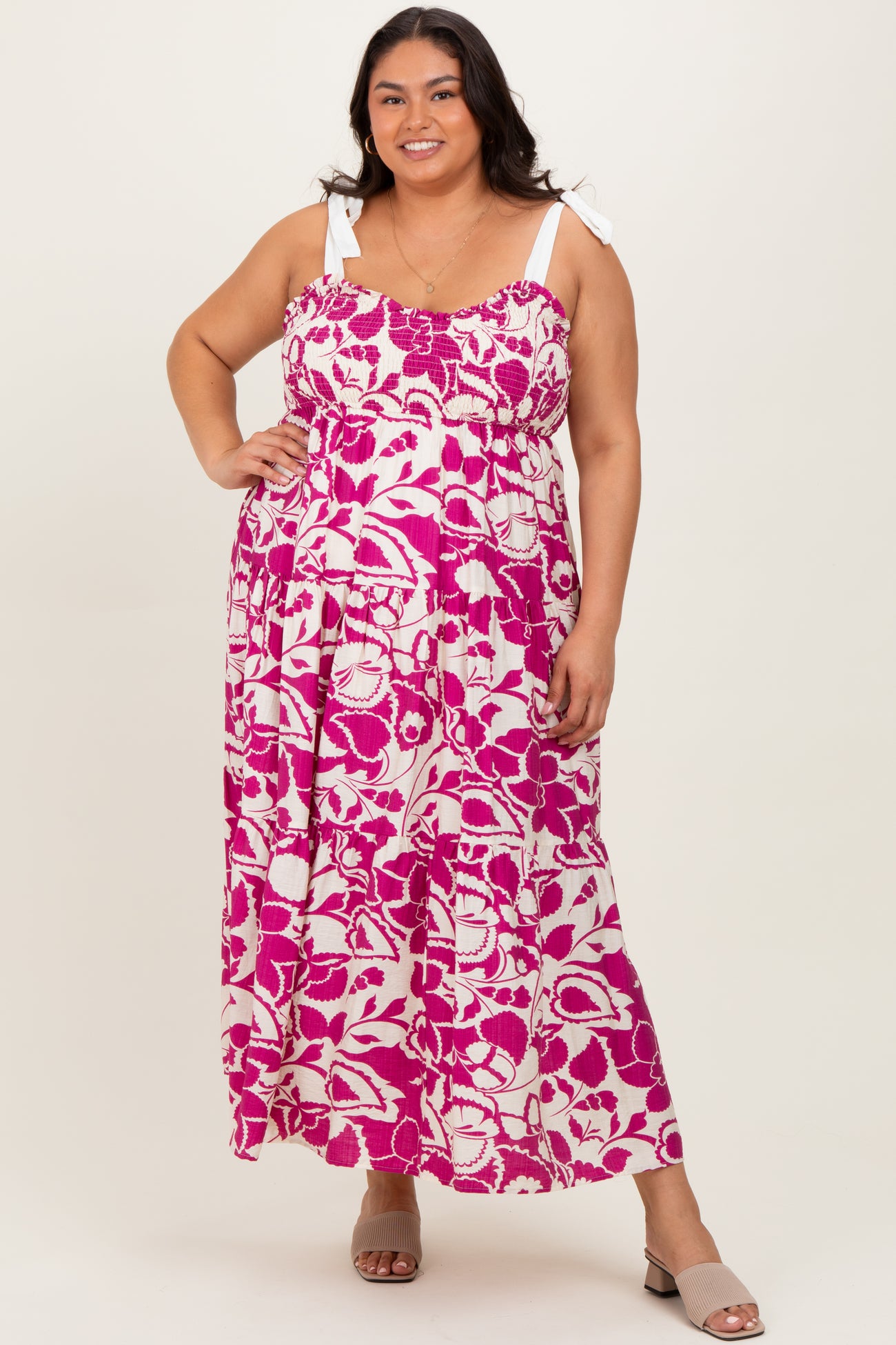 woman wearing a pink and white floral print maxi dress with tie straps in women's plus size