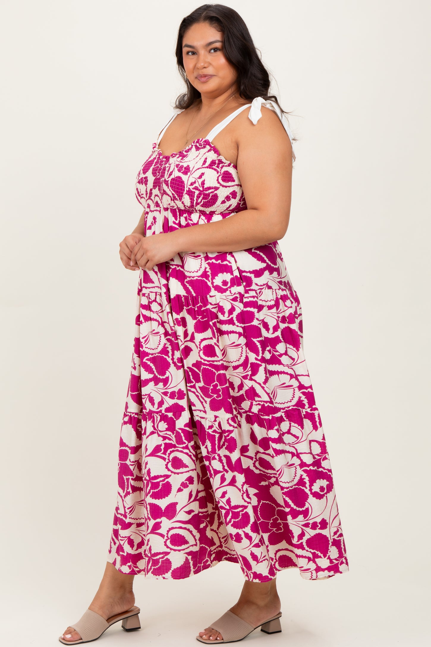 woman wearing a pink and white floral maxi dress with tie straps and a smocked bodice
