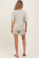 woman wearing a light gray maternity short set with a textured pattern, featuring loose-fitting shorts and a short sleeve top