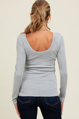 woman wearing a light gray ribbed maternity top with a scoop back and long sleeves