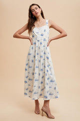 woman wearing a floral print midi dress with blue and white colors and spaghetti straps