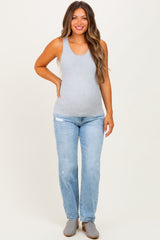 woman wearing a gray tank top and light blue distressed jeans, showcasing her baby bump