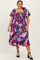 plus size woman wearing a colorful floral print midi dress with puff sleeves and a smocked bodice