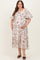 woman wearing a cream floral maternity dress with puff sleeves and a baby bump visible