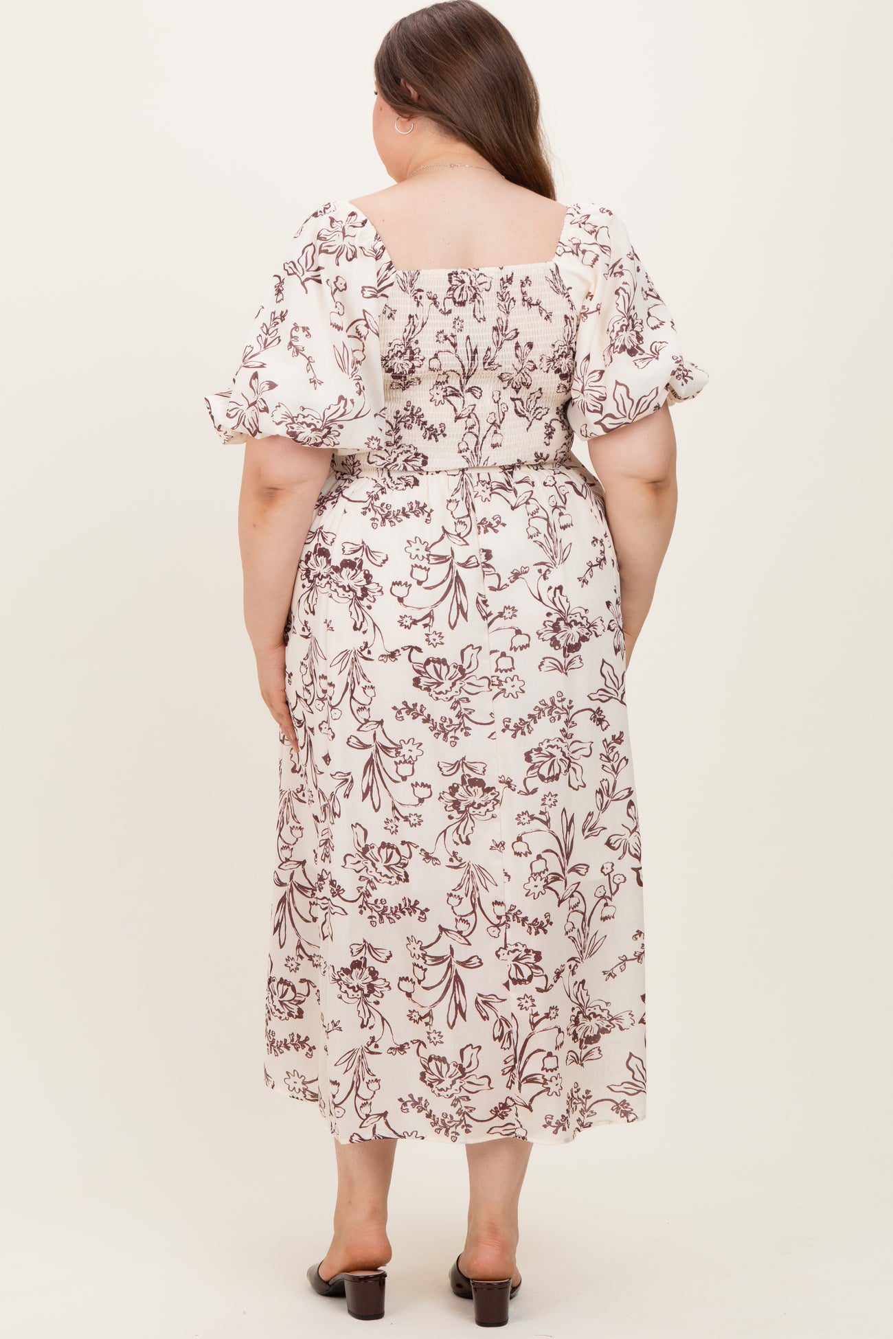 woman wearing a maternity plus floral print maxi dress with puff sleeves and a square back design