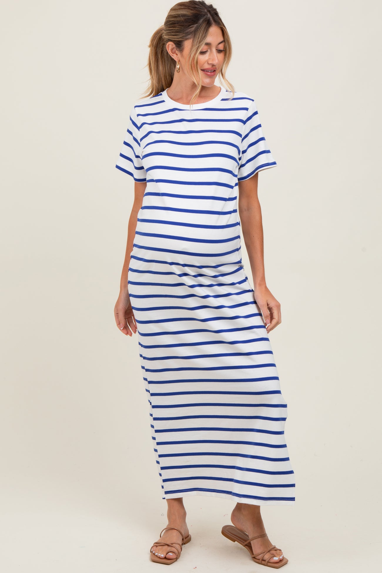 woman wearing a white maternity dress with blue stripes and a visible baby bump