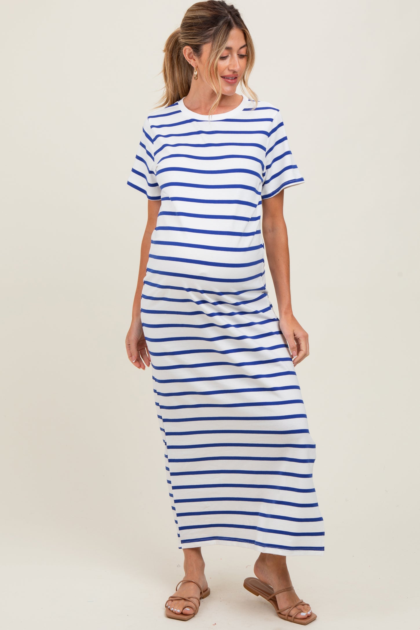 woman wearing a white maternity dress with blue stripes and a visible baby bump
