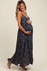 woman wearing a black and white patterned maternity maxi dress and holding her baby bump