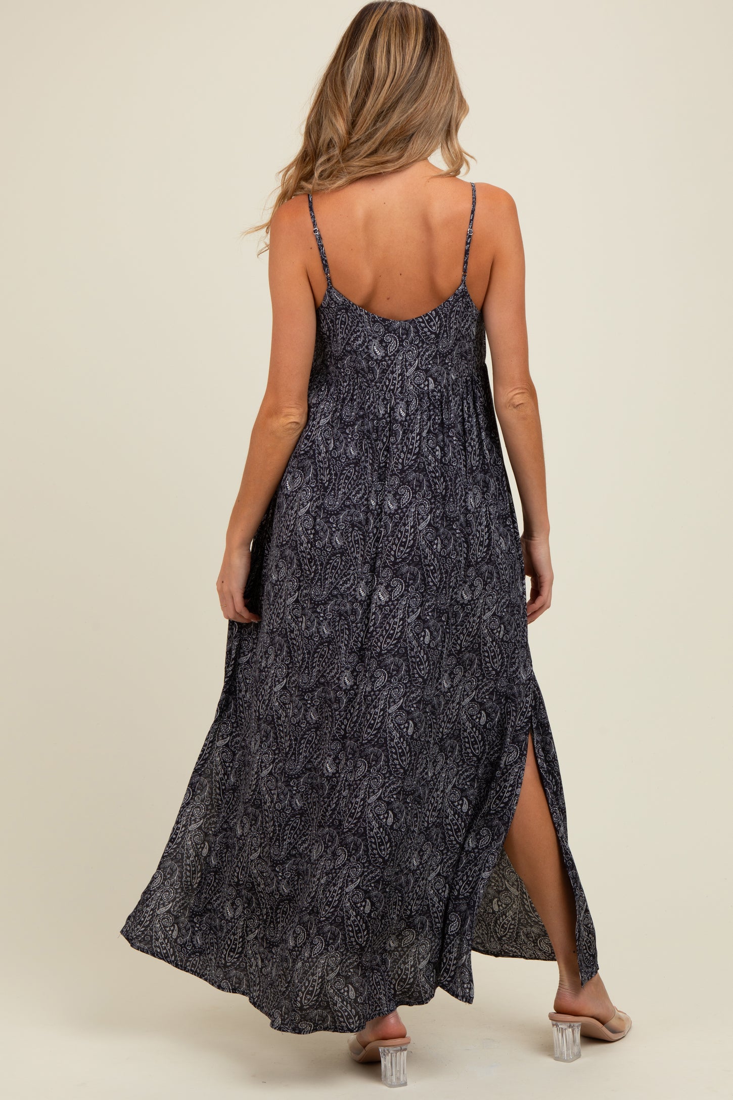 woman wearing a patterned black and white maternity maxi dress with adjustable straps and side slits